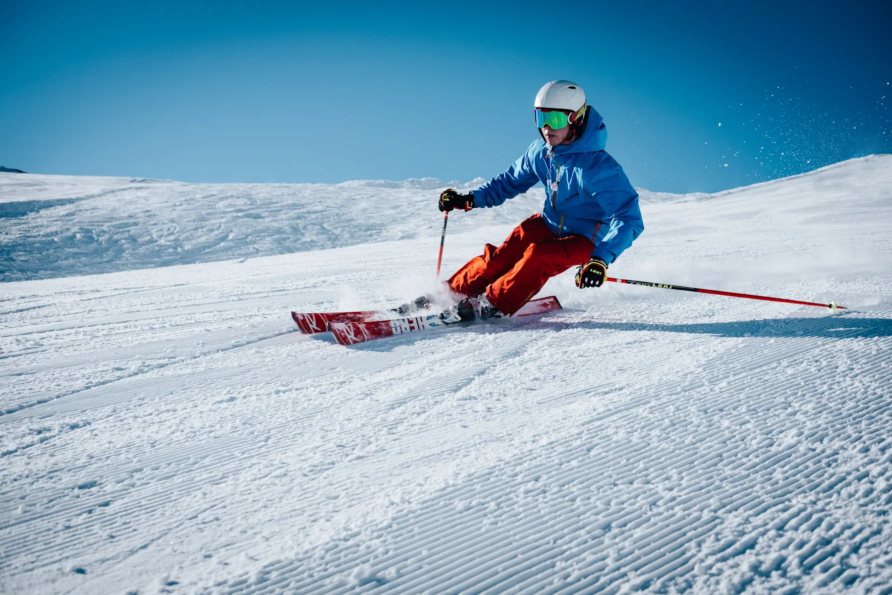 Skier carving through fresh snow on a bright day